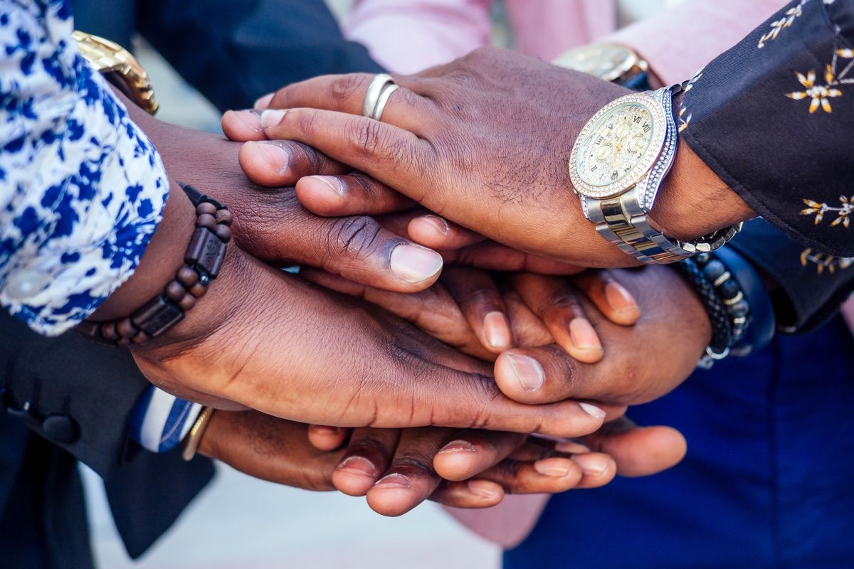 hands closeup of group black afro american friends men businessmen in stylish business suit, expensive wristwatch handshake teamwork .concept of successful business and good deal